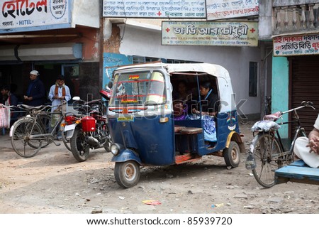 KUMROKHALI, INDIA - JANUARY 12: Auto rickshaw taxis on a road in Kumrokhali, India, January 12, 2009. Typical mileage for an Indian-made auto rickshaw is around 35 kilometers per liter of petrol.