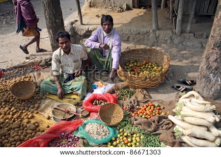 KUMROKHALI, INDIA - JANUARY 14: Tribal villagers bargain for vegetables on January 14, 2009. Kumrokhali, West Bengal, India. 42% of India falls below the international poverty line of $1.25 a day