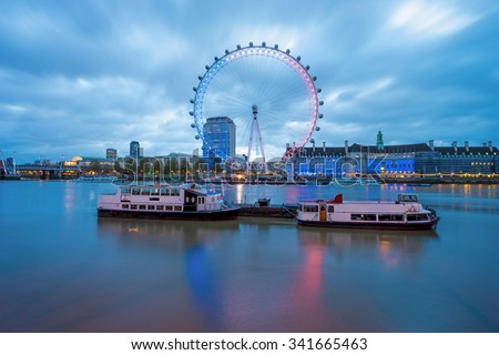LONDON, ENGLAND - NOVEMBER, 2015, The London Eye with French flag colors and two boats at sunrise - London\'s tribute to Paris attacks