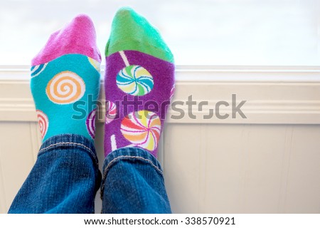 A pair of feet wearing brightly colored odd socks