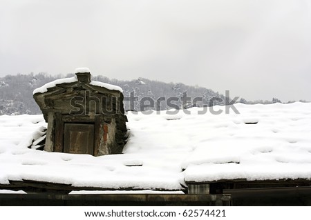 Dormer window on an old roof covered whit snow.