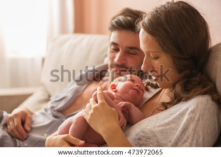 Portrait of a young family. mom, dad and newborn baby resting at home