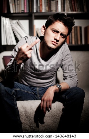 A young brunet man with obscene gesture