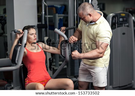Workout With Personal Trainer. The trainer forses woman to do exercise
