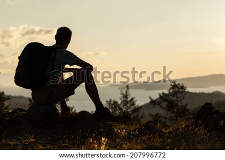 Hiker sits and looking into the distance