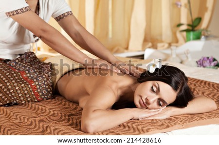 Thai massagist doing massage for european woman in spa salon Thai massagist doing massage for european woman in spa salon