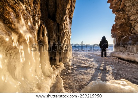 Man across the cave and looking at sunrise