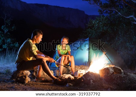 Couple in camping with campfire at night