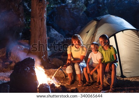 Mother with two children at the camping at night