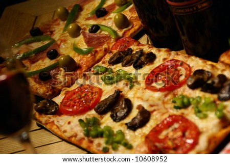 PIZZA open-faced baked pie of Italian origin, consisting of a thin layer of bread dough topped with spiced tomato sauce and cheese, often garnished with anchovies, sausage slices, mushrooms