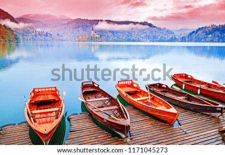 Bled, Slovenia. Great Slovenian nature - lake Bled in fall season. Amazing landscape - traditional Pletna boats at autumn background. Lake bled is famous place and popular European travel destination.