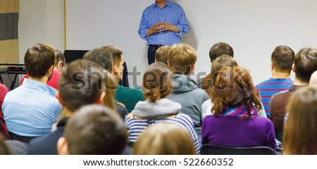 Education process at professor`s lecture in audience at university. Students are listening to teacher speech attentively.