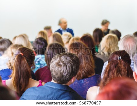 Students listening the professor\'s lecture, sitting rear in conference room. Education concept. Selective focus at attentive listener.