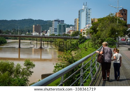 BLUMENAU, SANTA CATARINA/BRAZIL - SEPTEMBER 19 2015: Grandma and Grand daugther walking and looking at Itajai river, Blumenau, Santa Catarina/Brazil.