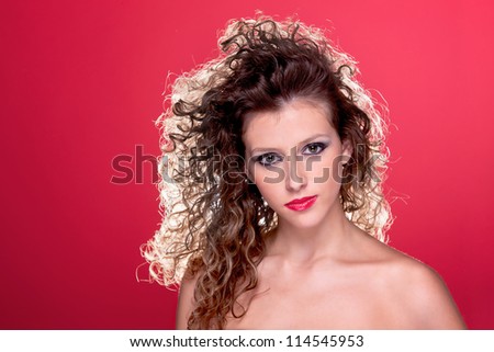 beautiful woman with curly hair, with light from behind, on red, studio shot