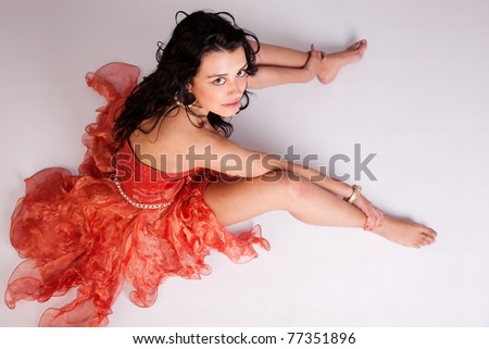 beautiful woman with elegant dress, on floor looking up, studio shot