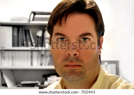 Man with Brown Hair and Stubble on Face in an Office
