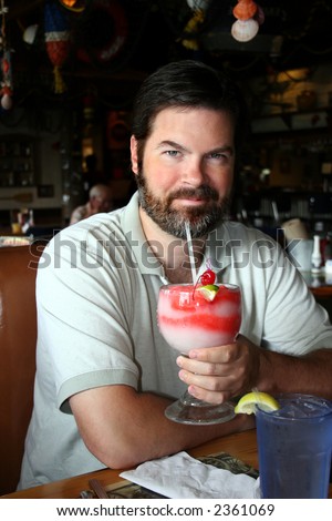 Bearded man drinking in a restaurant