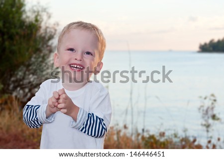 the two-year-old kid laughs against the sea