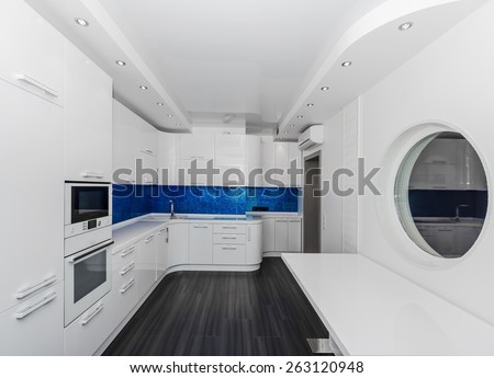 Specious modern white blue interior kitchen-dining room with the built-in household appliances