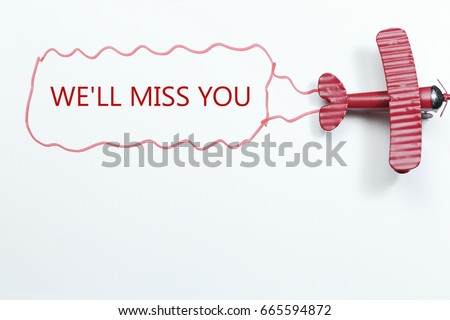 writing We\'ll Miss You red toy airplane with talk bubble on white background