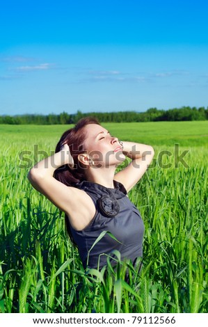 young woman with hands raised up in the wheat field
