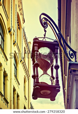 Decorative sand-clock in narrow street of the old Riga city, Latvia. Riga is the capital and largest city of Latvia, a major commercial, cultural, historical and financial center of the Baltic region