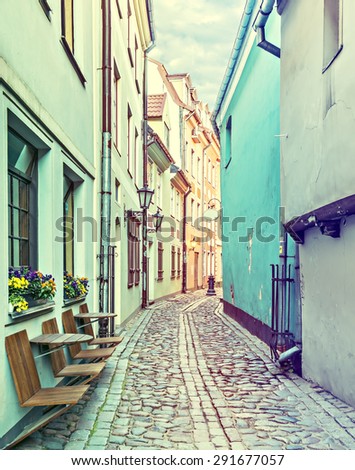 Narrow street in old city of Riga. Image toned in vintage warm colors for inspiration of retro style effect