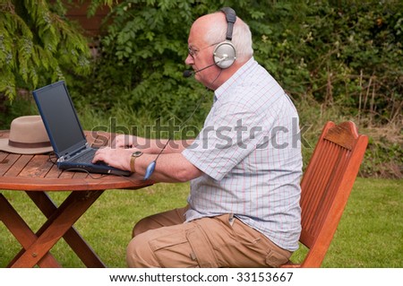 senior male outside using laptop to make voip call