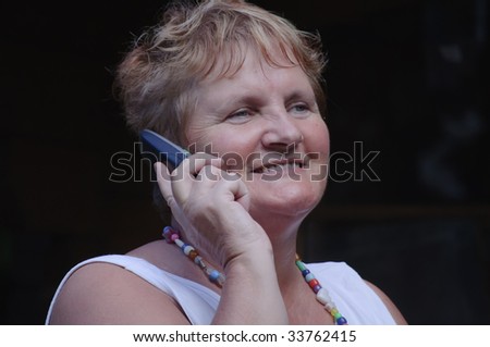 close portrait of senior lady on phone smiling