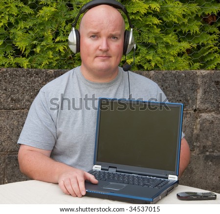 middle age man using laptop and voip , advert on laptop
