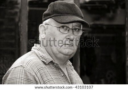 photo black and white portrait of an older senior male glasses and cap