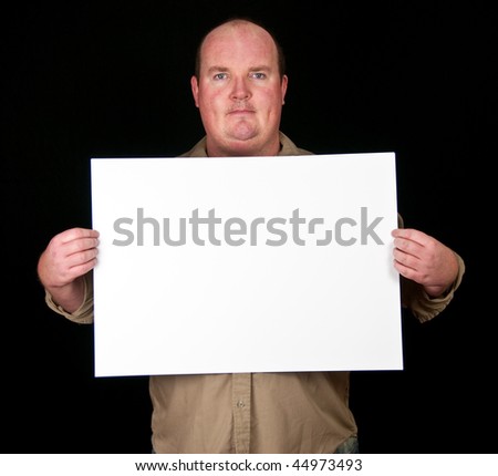 stock photo casual fat man holding an blank paper over a black background