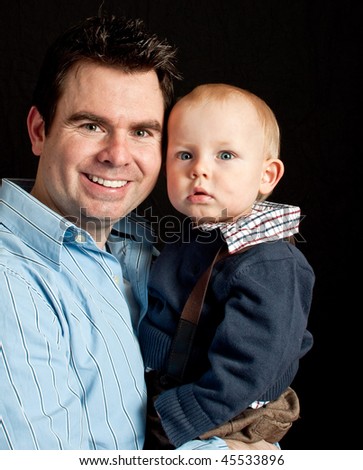 photo of father and his baby son on black