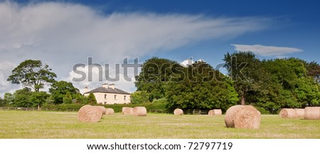 photo scenic irish cottage on a farm with hay field