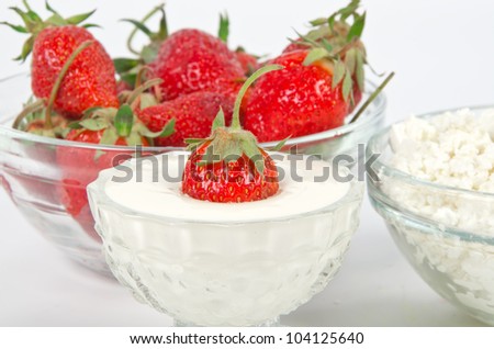 ripe strawberry in ice-cream bowl with sour cream