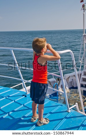 boy standing on the deck of a ship