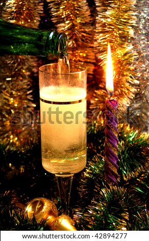 fill glass champagne by candle in the New Year\'s Day