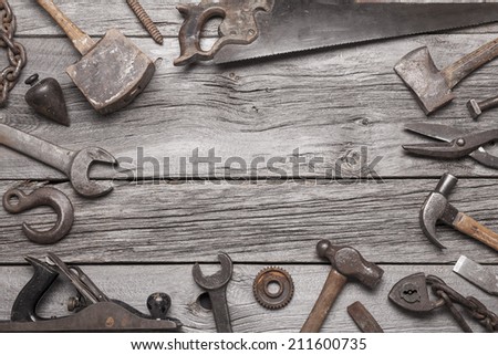 A border made up of vintage tools on a background of grey barnboard.