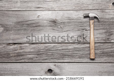 An old hammer on a rustic wooden background with lots of copy space.