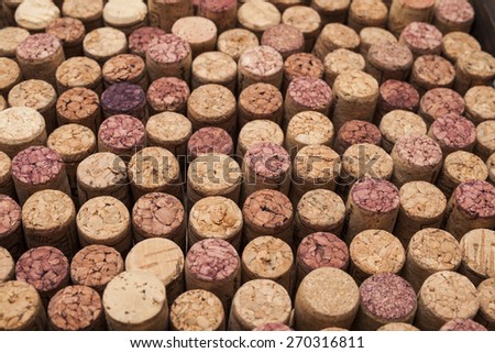 A photograph of rows of used wine corks. Some of the corks are stained from holding red wine.