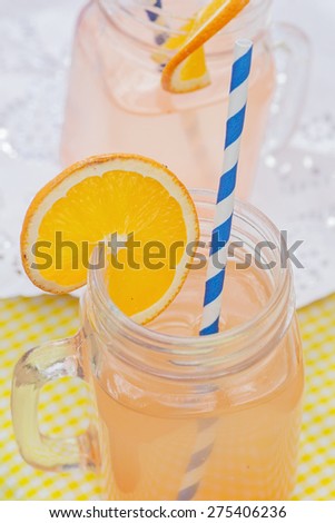 Fresh orange juice in a vintage glass with straw.