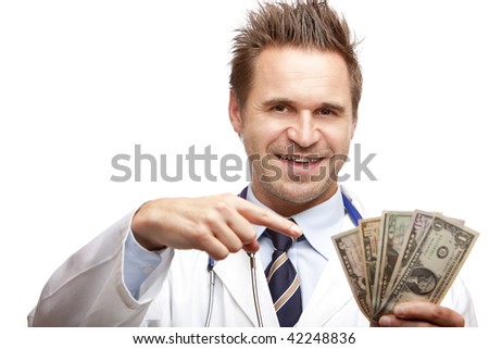 Closeup of doctor holding a  bundle of us dollar bills in his hand and points with other hand on it. Isolated on white.