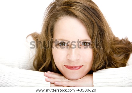 Young woman lying on floor with chin on hands is smiling happy into camera. Isolated on white.