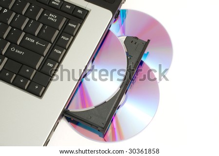 CD or DVD being loaded into Laptop computer indicating piracy or home movie and music creation