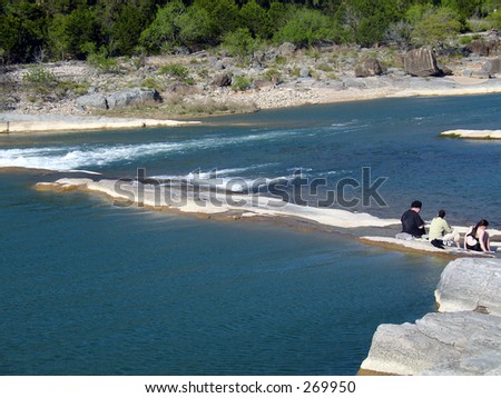 A family cooling their feet at Pedernales Falls State Park in central Texas.