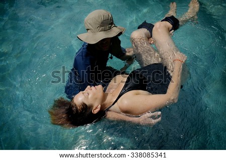 BALI, INDONESIA - MARCH 31, 2012: A male Watsu therapist guides his female patient in a swimming pool during a \'Watsu\' water-massage session on March 31, 2012 in Ubud, Bali, Indonesia.