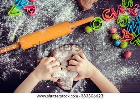 Young girl\'s hands kneading dough. Easter baking preparation. Close-up of child\'s hands baking cookies. Easter eggs. Easter food concept. Top view.