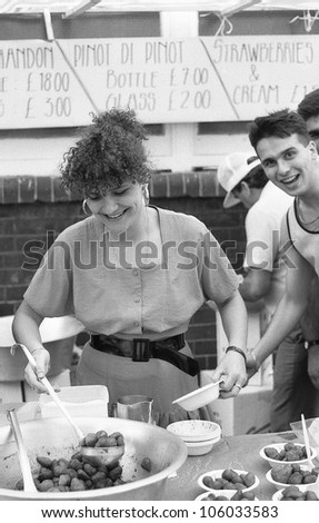 LONDON - JULY 21: A woman ladles strawberries at the Italian street party in Warner Street, Clerkenwell on July 21, 1990 in London. The event follows the annual procession of St.Mary of Carmel.