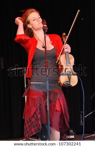 TENTERDEN, ENGLAND - JUNE 30: Dulcima Showan, violinist with British acoustic Fip Fok band Coco and The Butterfields, performs at the Tentertainment music festival on June 30, 2012 at Tenterden, Kent, England.